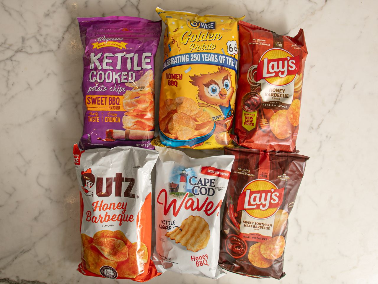 Six bags of various barbecueflavored potato chips arranged on a surface