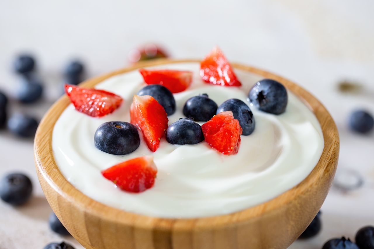 A bowl of yogurt topped with blueberries and strawberries