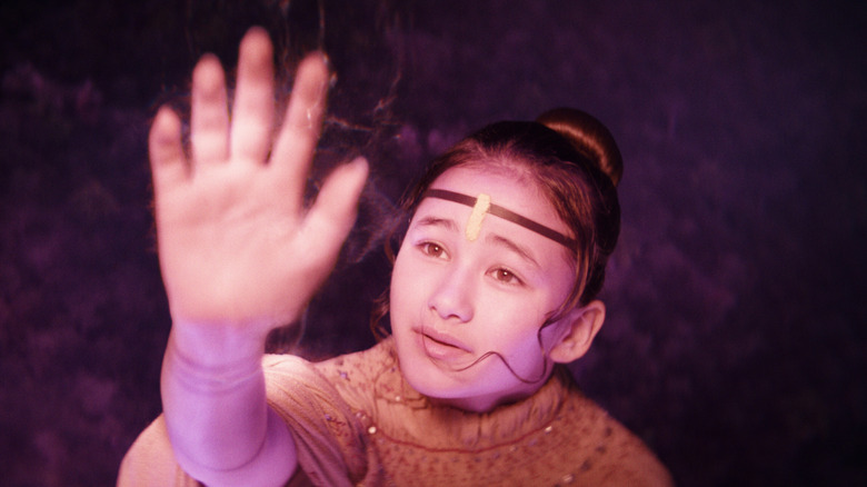 Jia holding up hand to glowing light in Godzilla x Kong: The New Empire (2024)