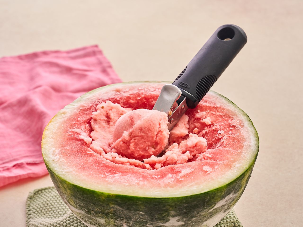 Watermelon filled with watermelon ice cream and a scoop placed in it