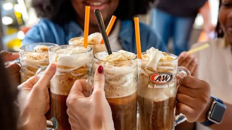 A group of people enjoye A&W root beer floats at the restaurant.
