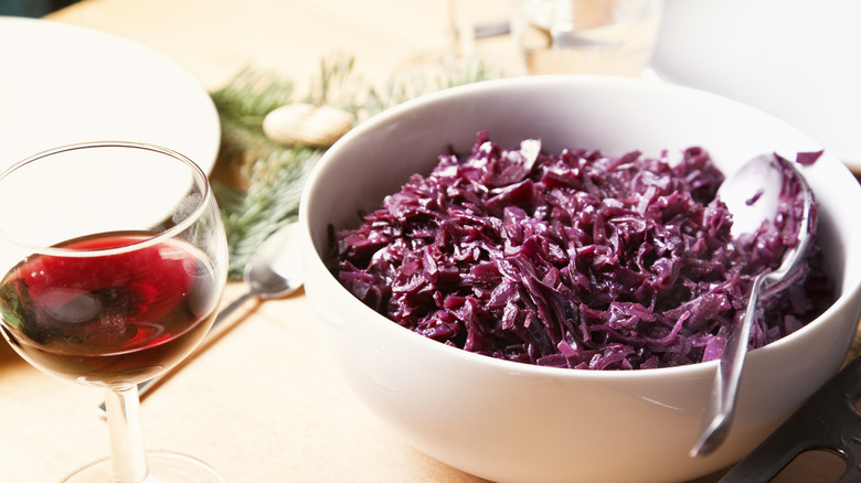 Bowl of red cabbage alongside glass of wine