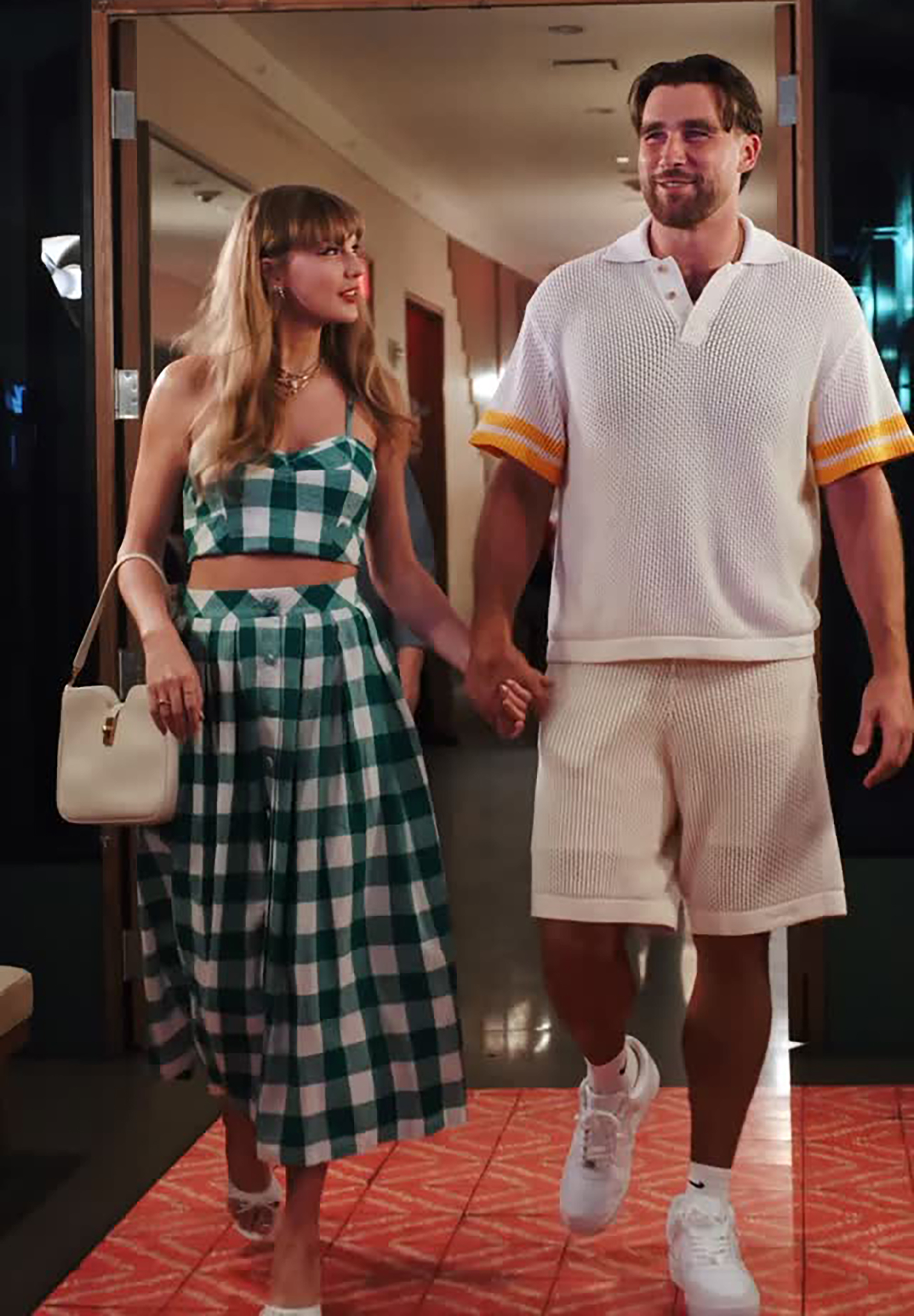 Taylor Swift and Travis Kelce holding hands and walking together.