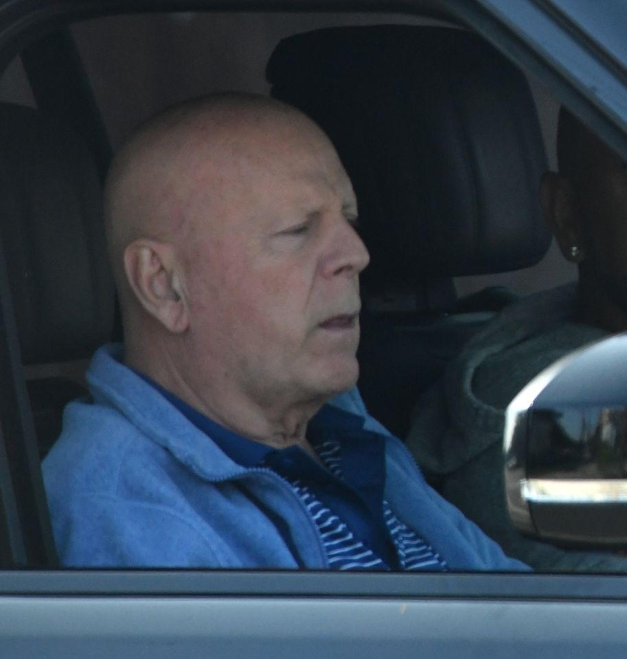 Bruce Willis in a blue jacket in a car in 2024