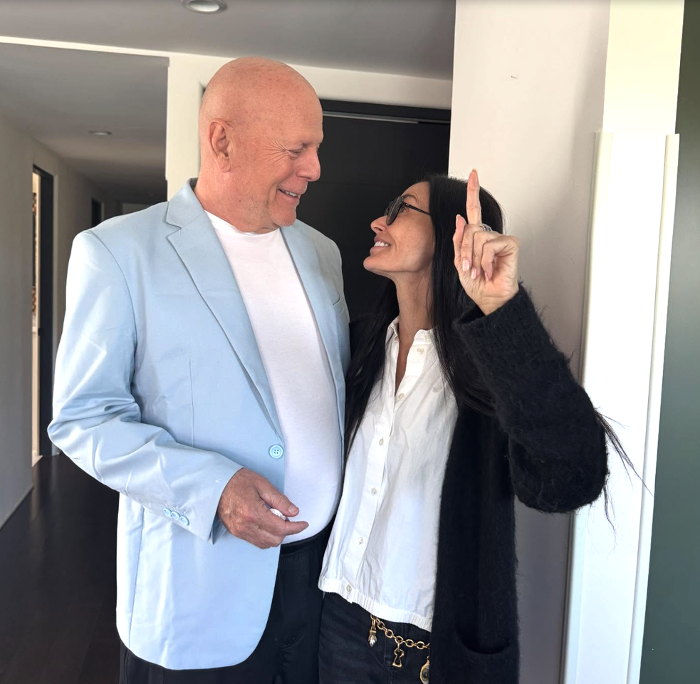 Bruce Willis in a blue suit jacket with Demi Moore in a fuzzy cardigan