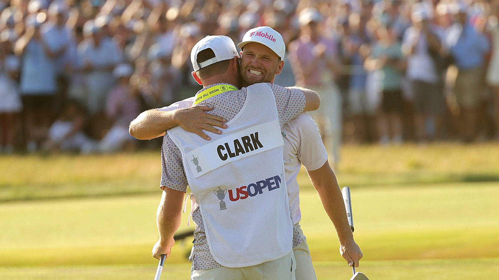 Wyndham Clark hugs his caddie on the 18th green at the US Open