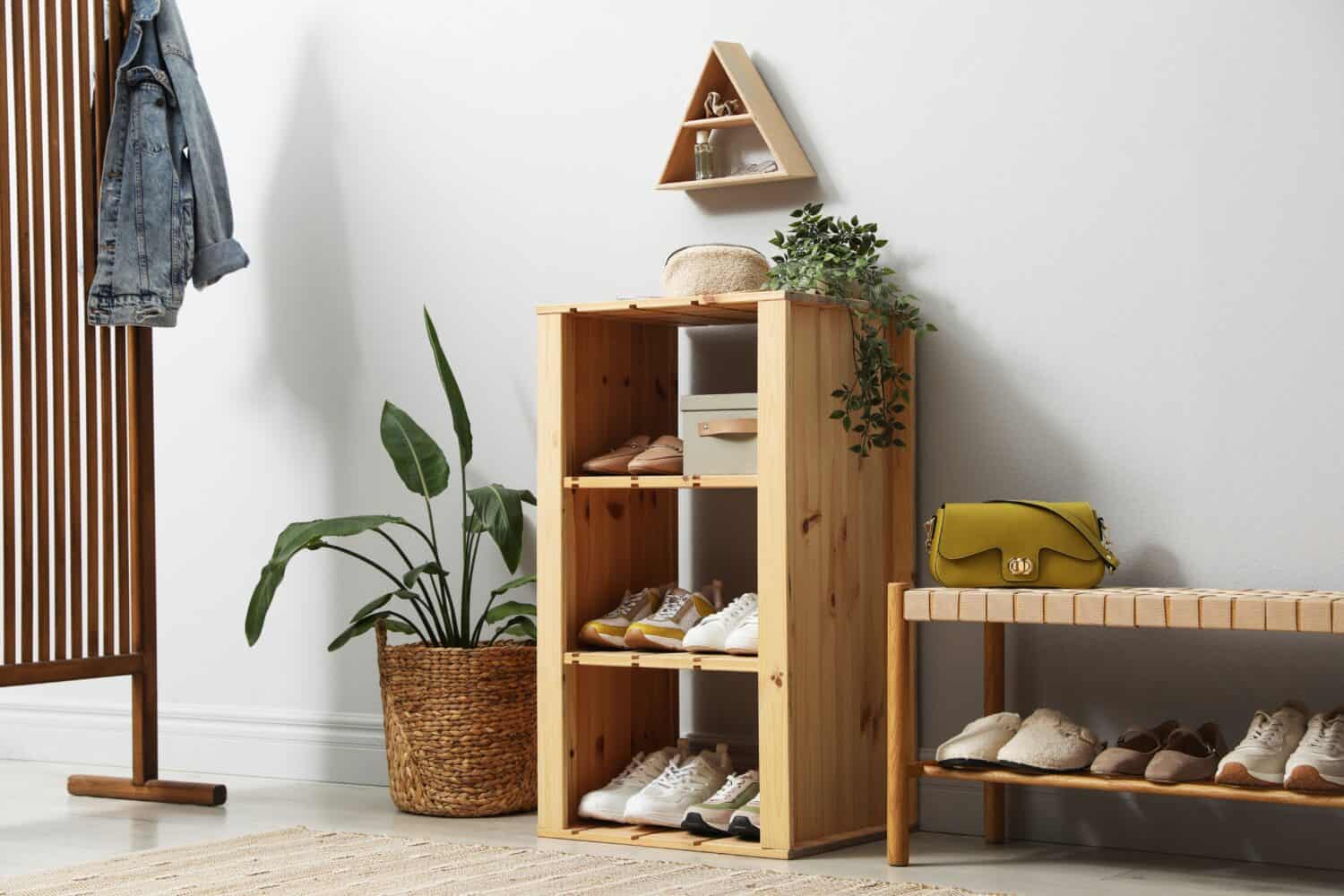 Different footwear on shelves in entryway. Shoe storage