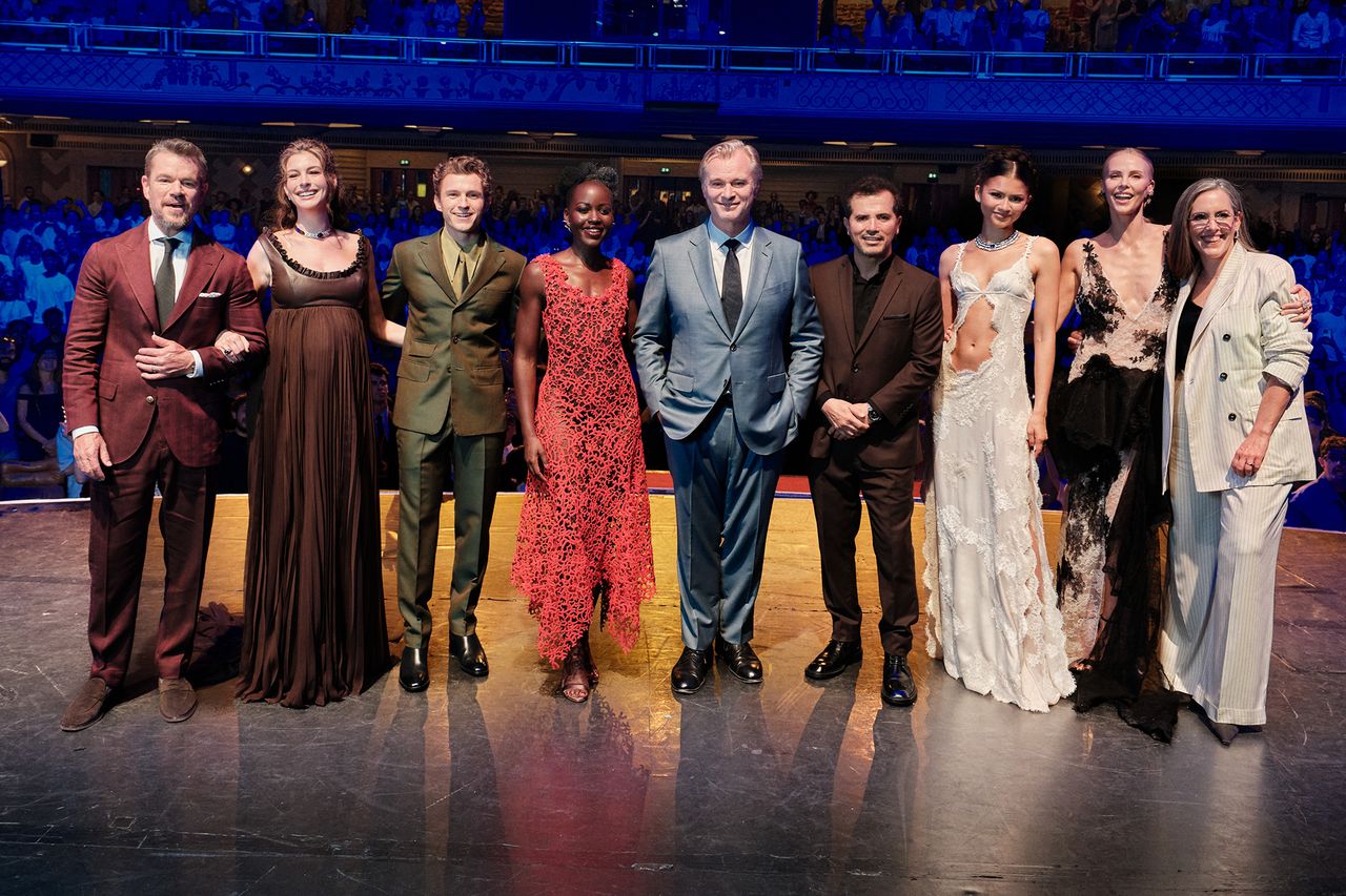 Matt Damon and Christopher Nolan standing with others on a stage at an event