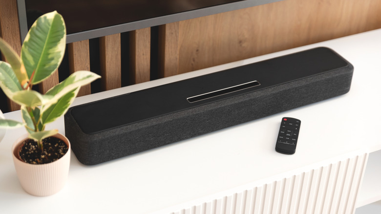A soundbar placed beneath a TV on a media console.