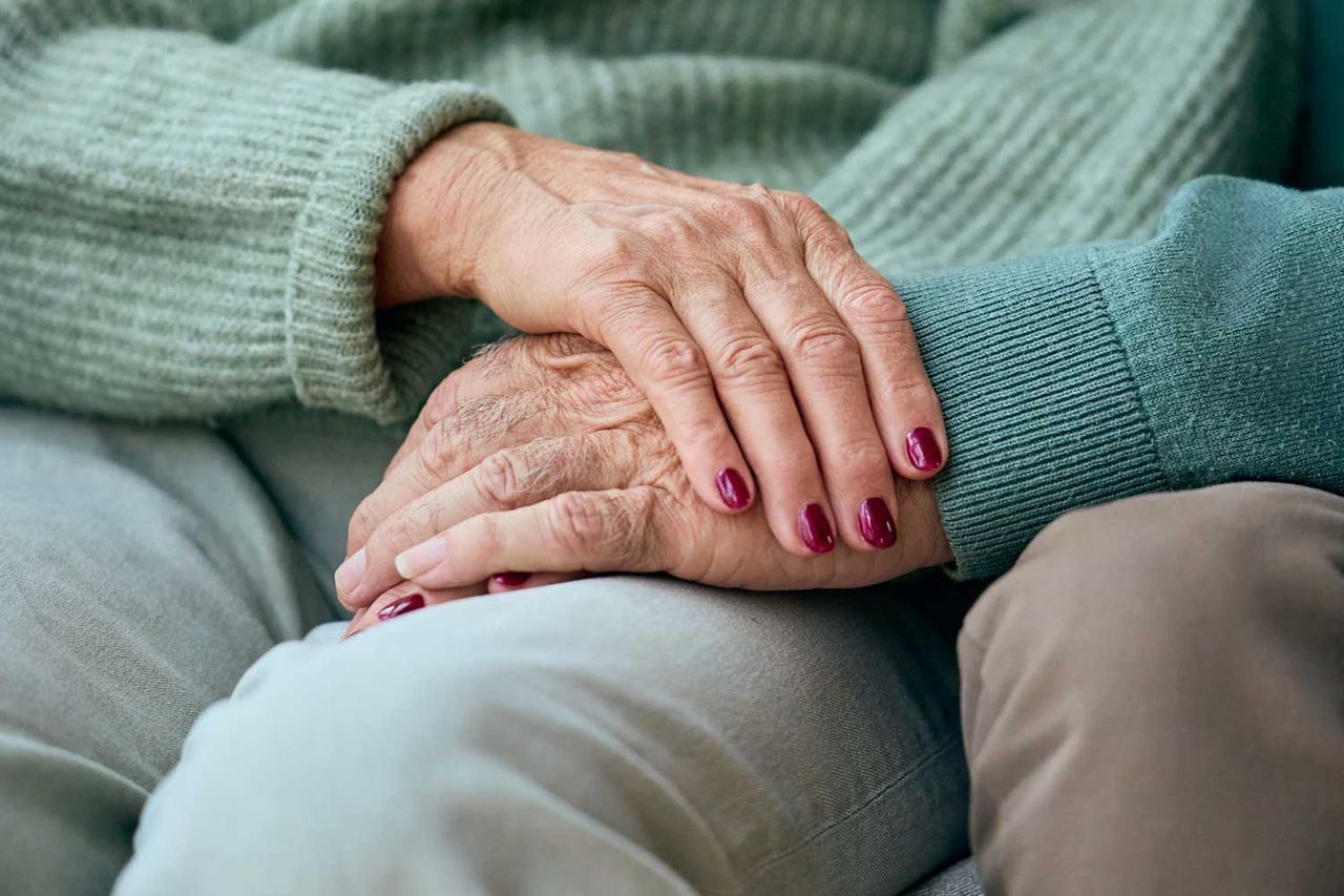 Gentle moment of elderly hands resting together, conveying care, support, and warmth between loved ones.