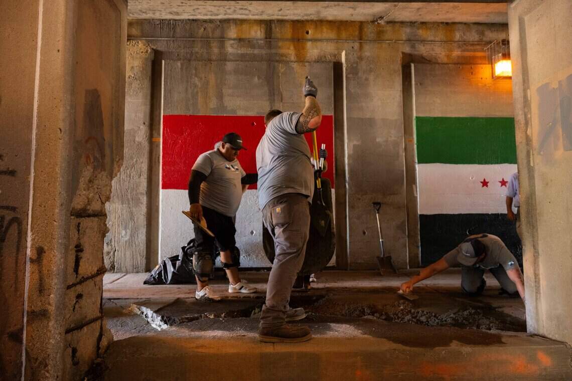 Employees of Thrasher Foundation Repair perform work underneath an overpass on Van Brunt Boulevard in Kansas City, on Monday, July 20, 2026.