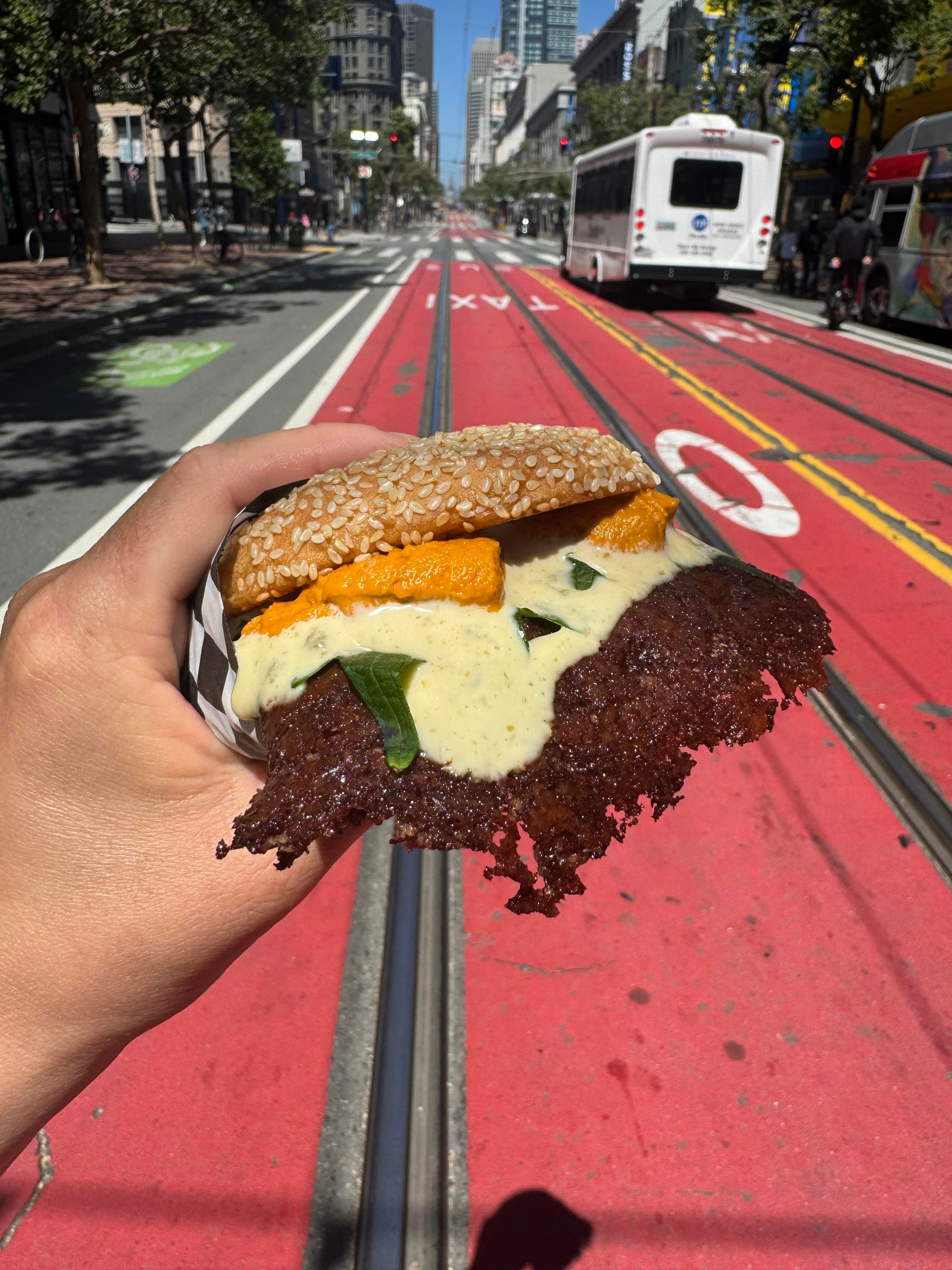 The uni burger at Smish Smash with a lacy patty, cheese, and pieces of uni on top.