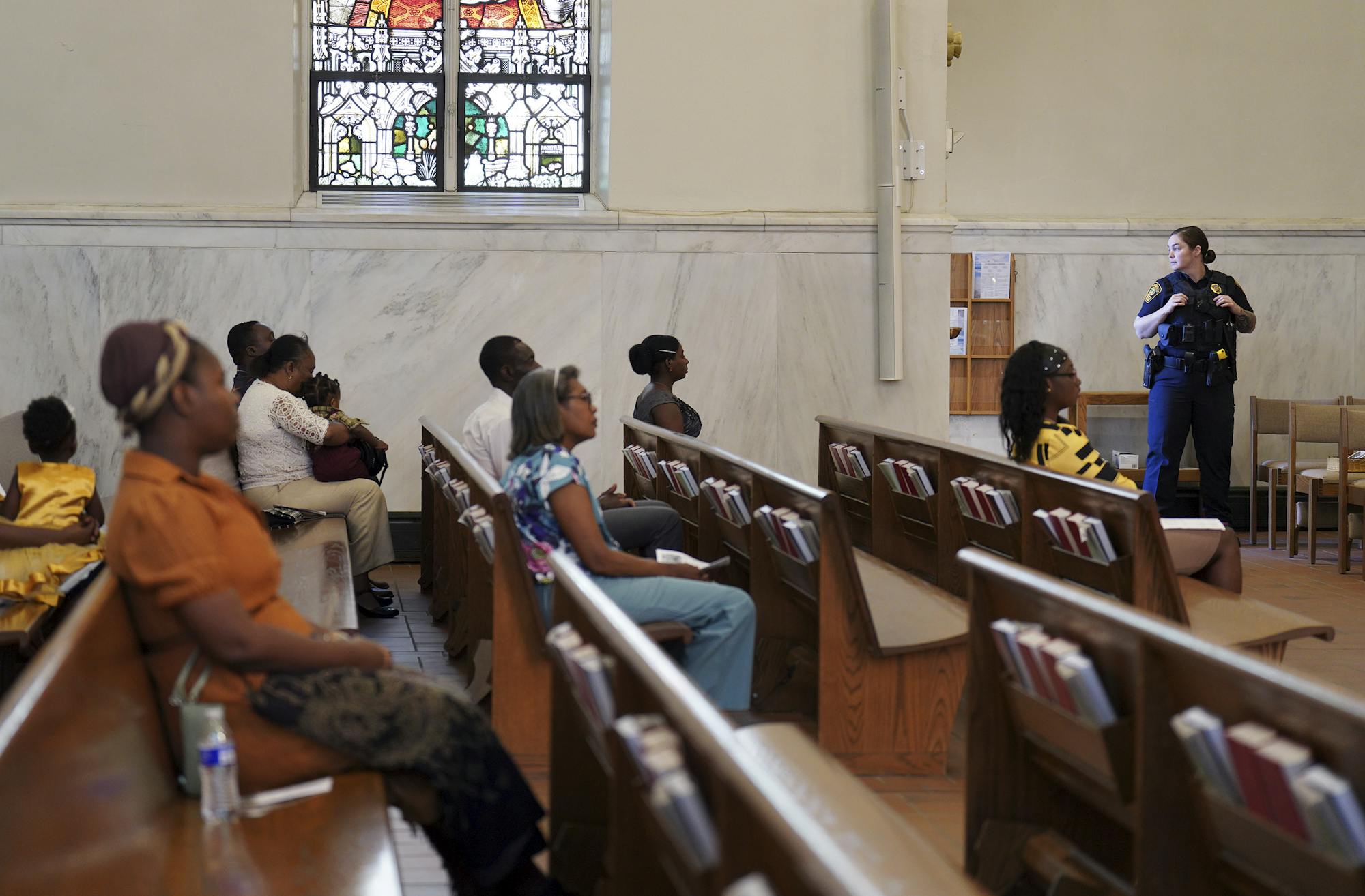 A police officer stands watch to protect churchgoers during a service in support of the Haitian community at St. Raphael Catholic Church in Springfield, Ohio, on Sept. 15, 2024.