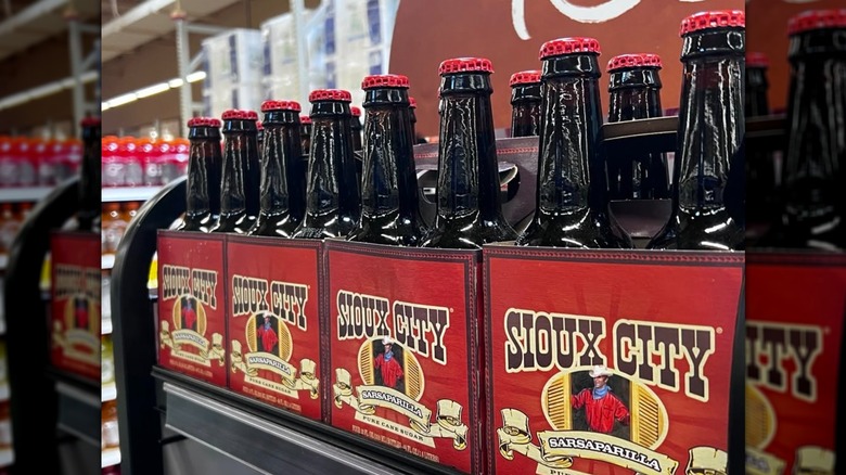 Four packs of Sioux City Sarsaparilla in glass bottles on a store shelf