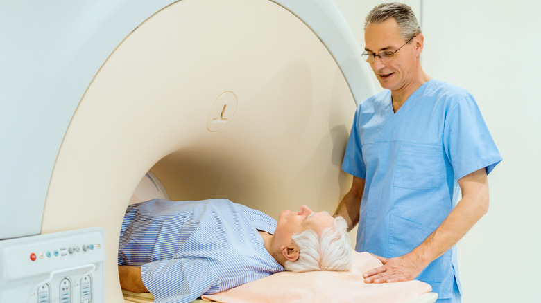 Radiologist talking with man undergoing prostate MRI
