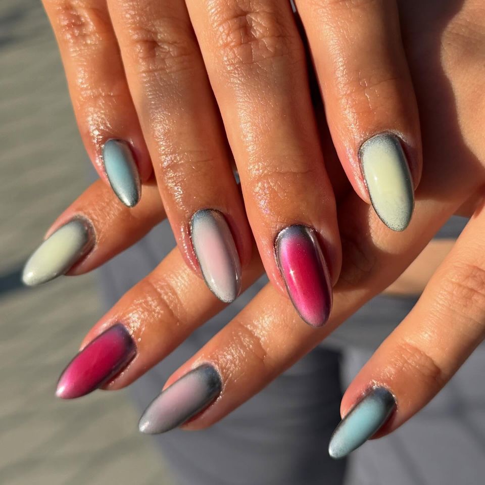 Closeup view of hands showcasing manicured nails with a multicolored design