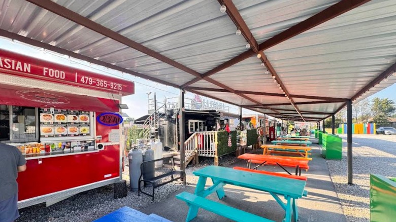 The trucks and colorful picnic tables of the Centerton Food Trucks Park