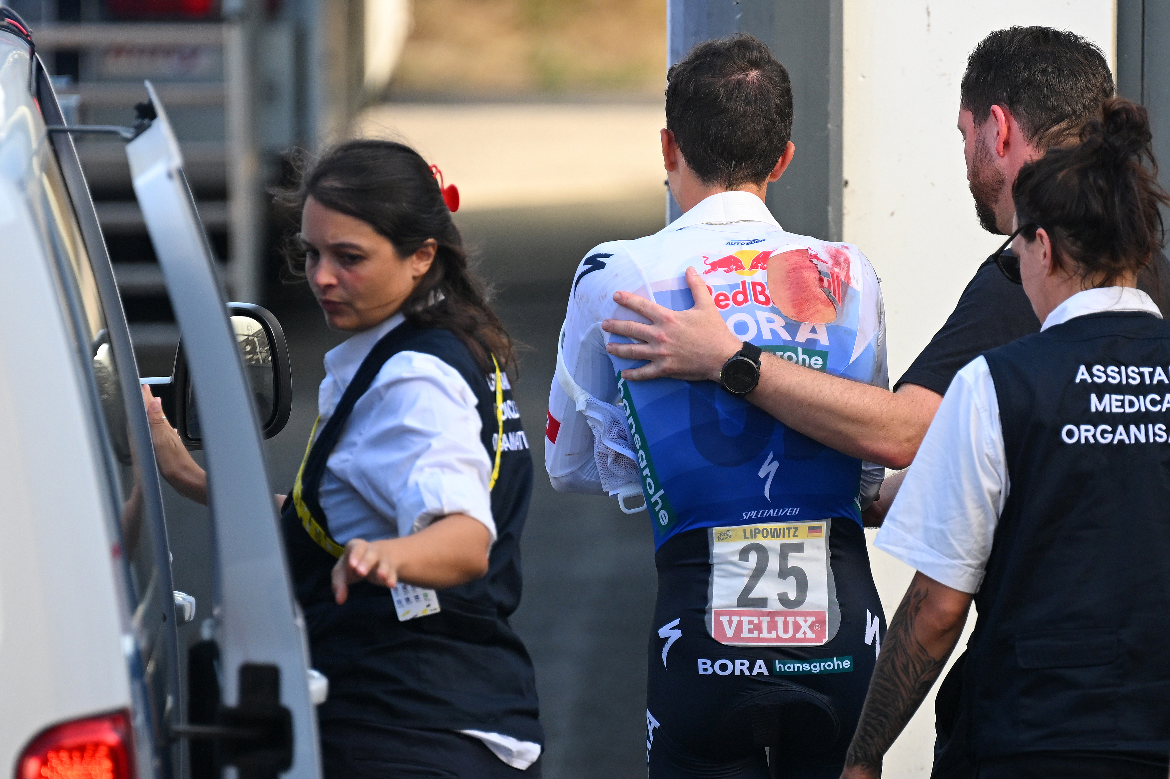 Lipowitz escorted by medical staff after his crash on stage 16