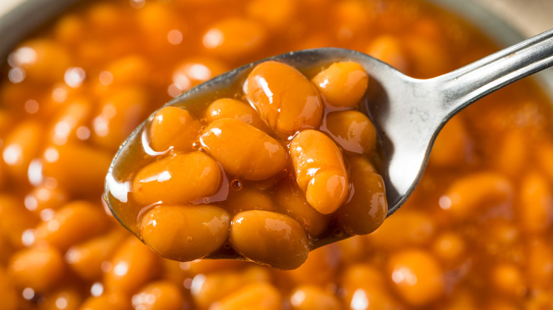 Canned beans being lifted up with a spoon