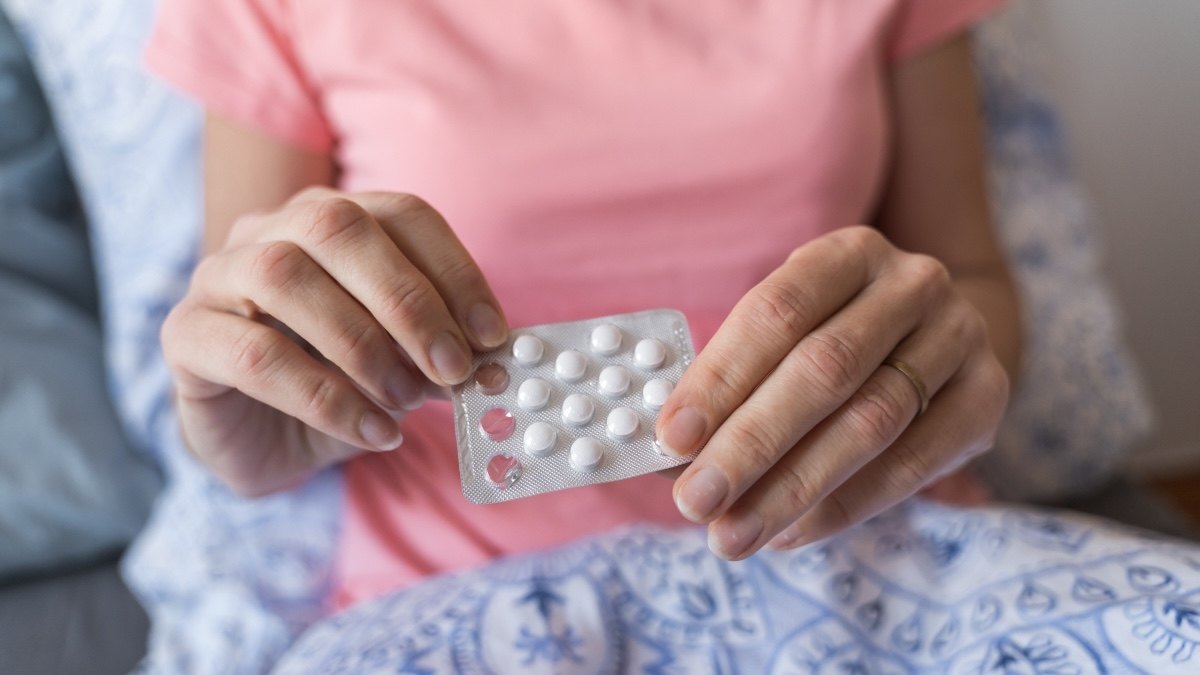 Close-up of a woman's hands holding progesterone pills