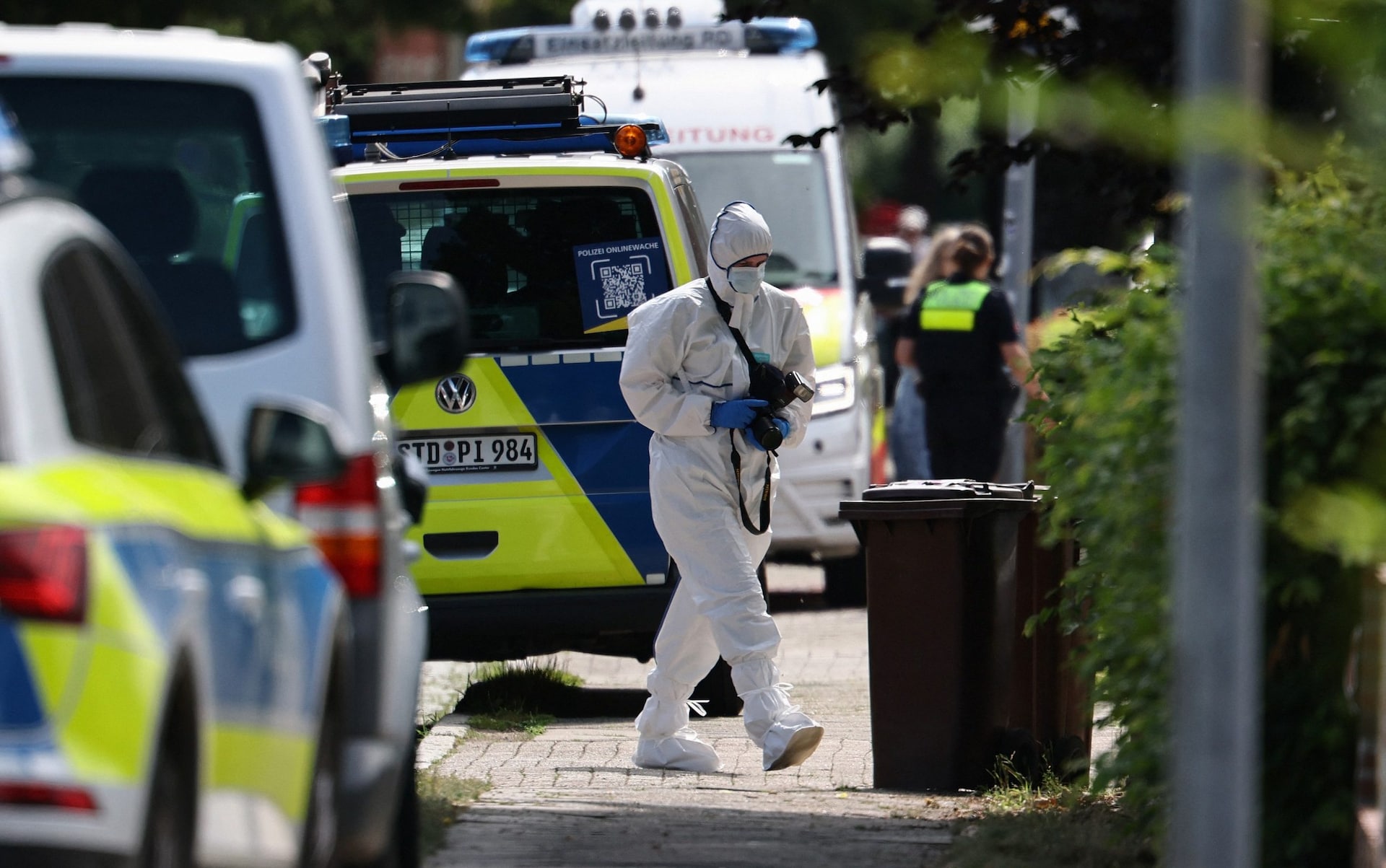 forensic Police officer with a camera works near the scene where five people were killed in a shooting in Stade