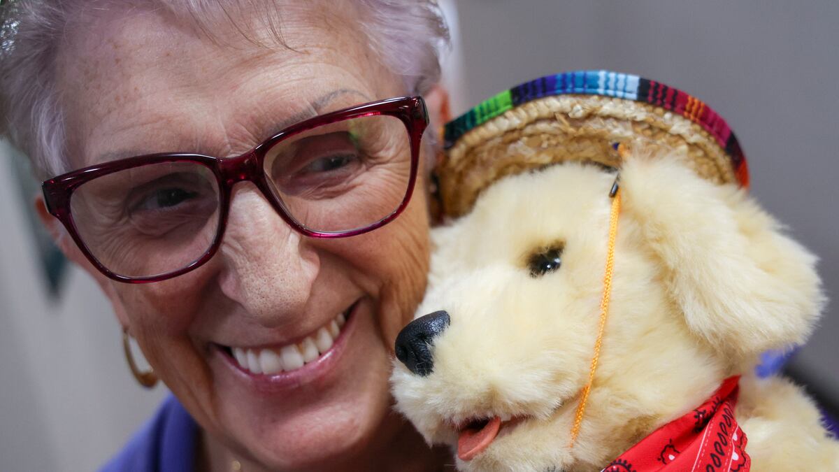 Irena Domanski, 75, cuddles with her new robo-pet, Spencer, during a ceremony in May. ©Douglas R. Clifford