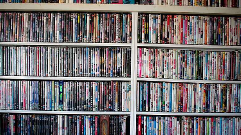 A shelf shows a colorful stack of Blu-ray and DVDs.