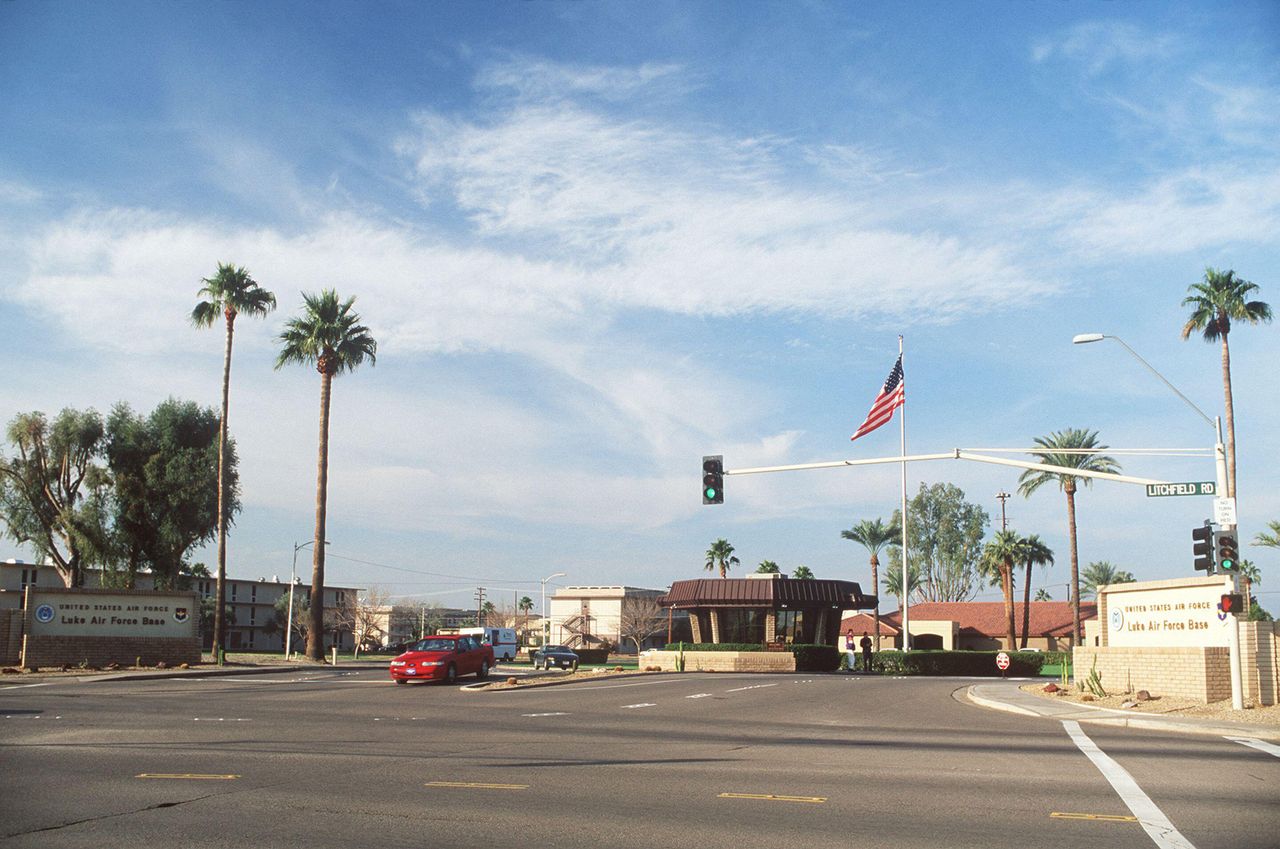 A long-range view of the main gate with the base signs in the foreground. Base: Luke Air Force Base State