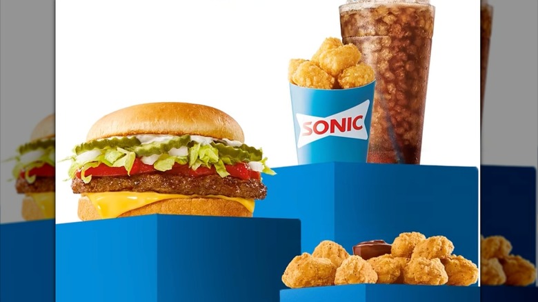 Cheeseburger, chicken nuggets, tater tots, and glass of cola from Sonic Drive-In