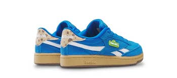 Blue Reebok sneakers with a retro design, gum sole, and playful details, suitable for casual wear and shopping enthusiasts