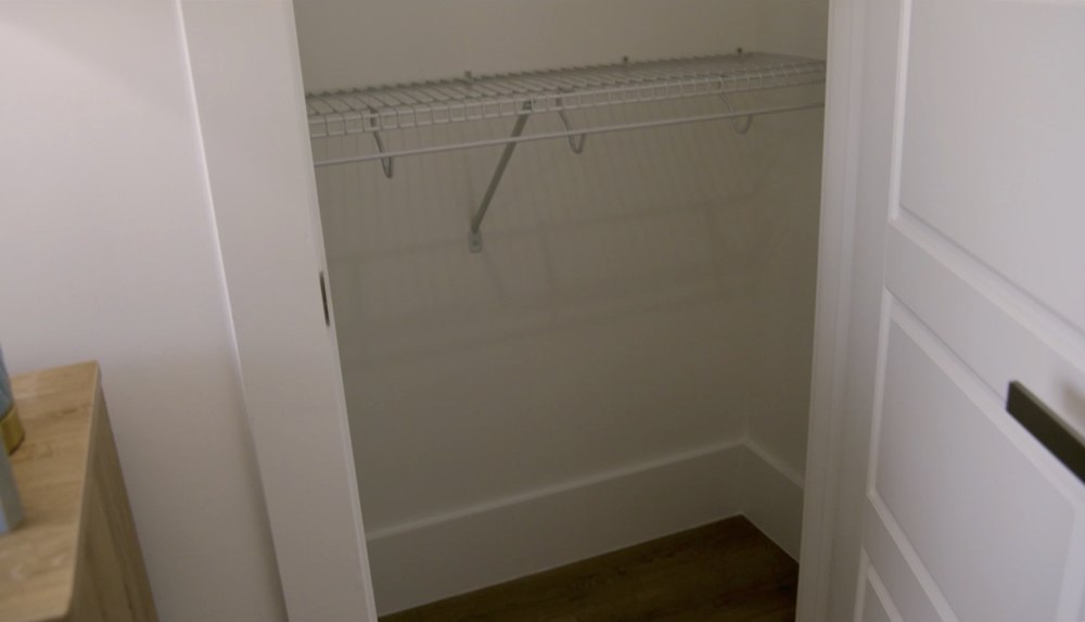 The closet inside the second bedroom has the same wired shelving as the primary closet, but is even smaller.