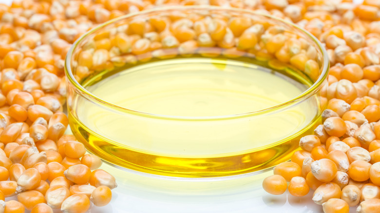 Dried corn kernels surrounding a bowl of corn syrup