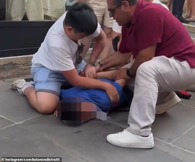 Shocking video footage shows a group of tourists had turned the suspect over and pinned him to the floor, holding his arms behind his back