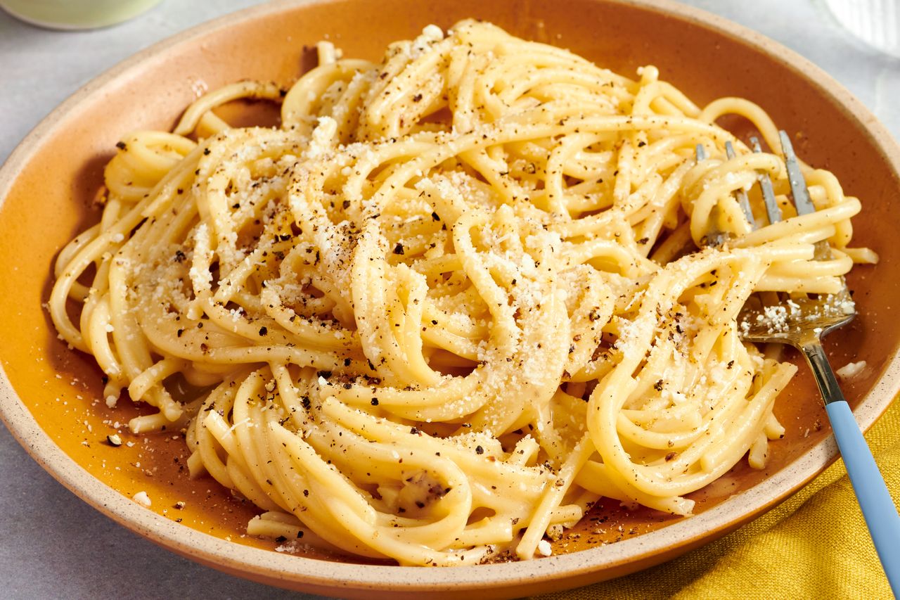 Plate of spaghetti cacio e pepe with a fork on the side