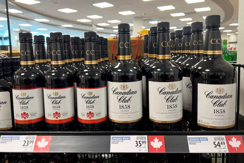 Bottles of Canadian Club whiskey, with maple leaves on the price label to denote a Canadian product, stand on a shelf in Vancouver