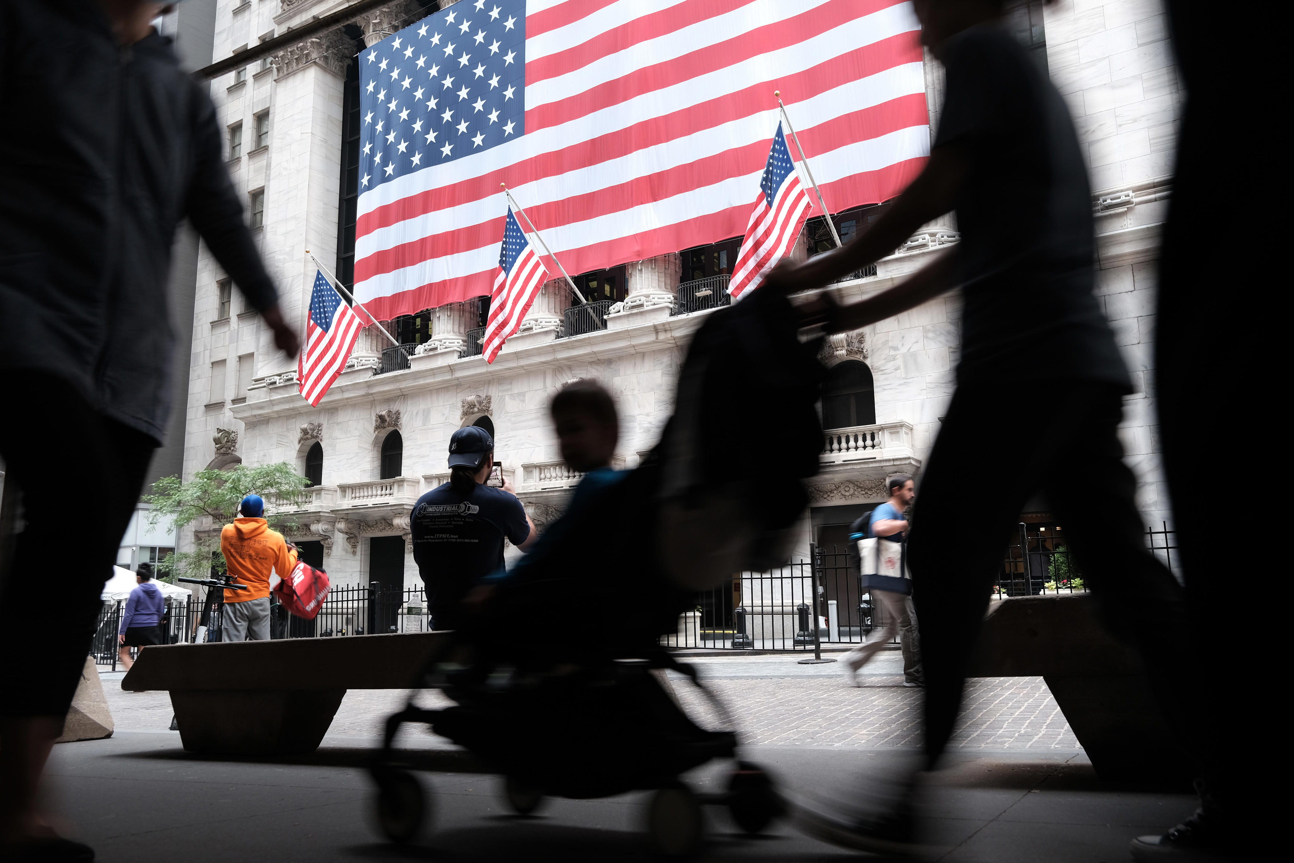Silhouette of pedestrians walking past the New York Stock Exchange