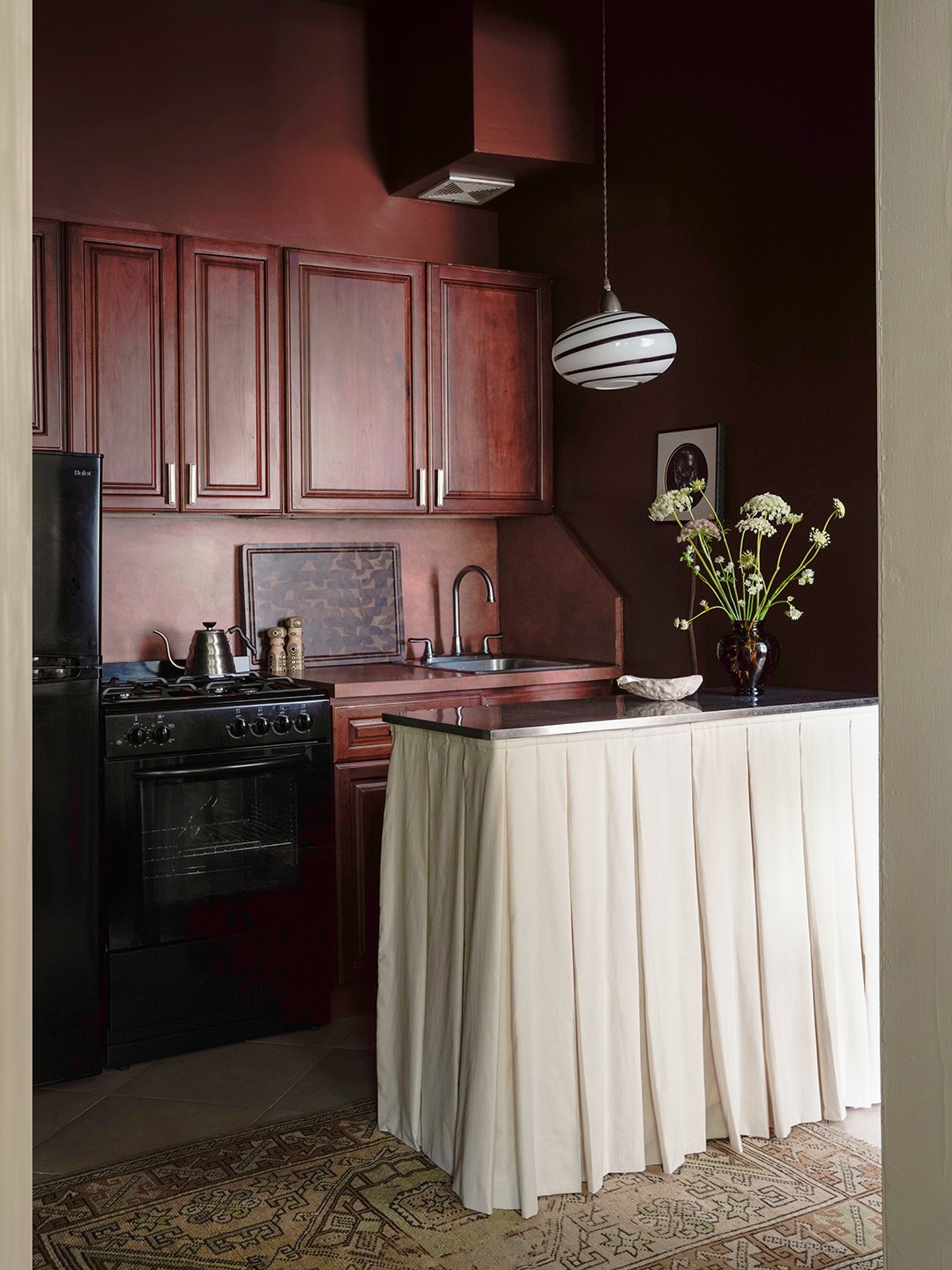 dark cinnamon kitchen with a white skirted island