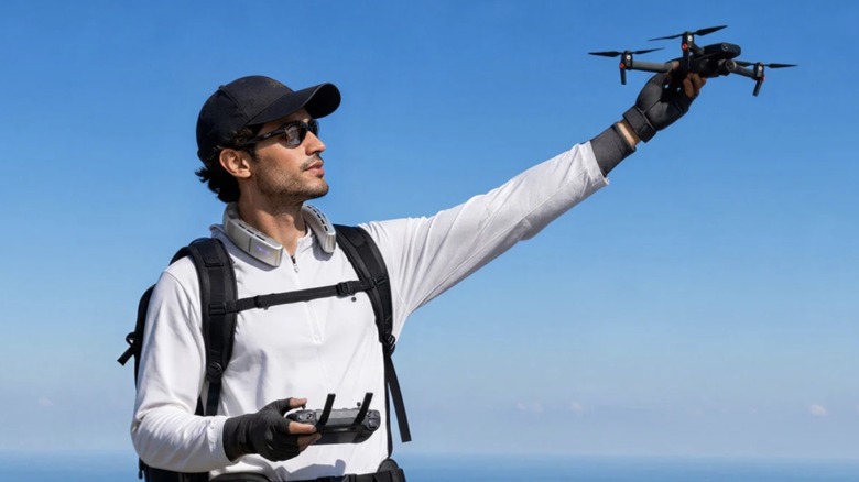 A mn wearing the Coolify Cyber Fold while launching a drone.