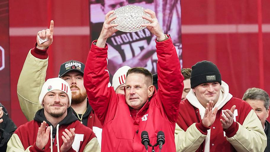Indiana Hoosiers head coach Curt Cignetti holds up the coaches trophy.