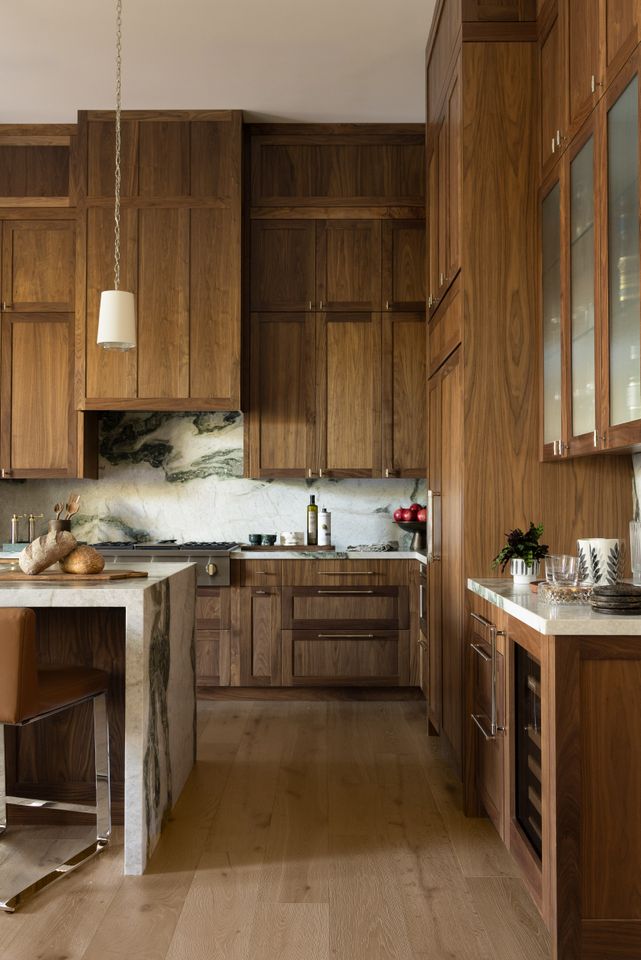 Modern kitchen with wooden cabinets a marble backsplash and a central island