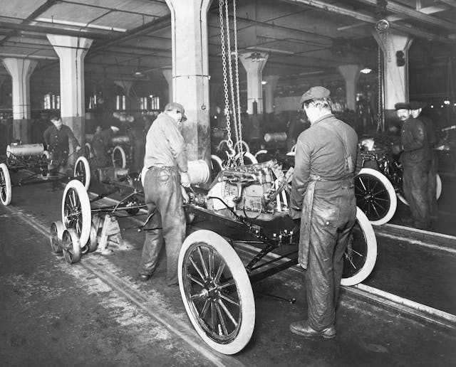 Factory workers at the Ford Motor Company plant assemble a Model T automobile