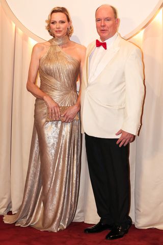 Prince's Albert II of Monaco and Princess Charlene of Monaco pose as they arrive to attend the 77th annual Monaco Red Cross Ball gala charity event