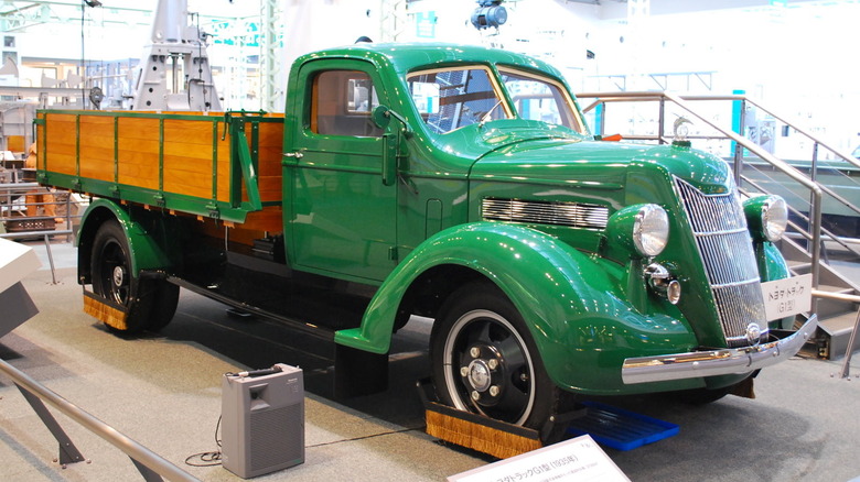 A green 1935 Toyoda Model G1 Truck on display in a building