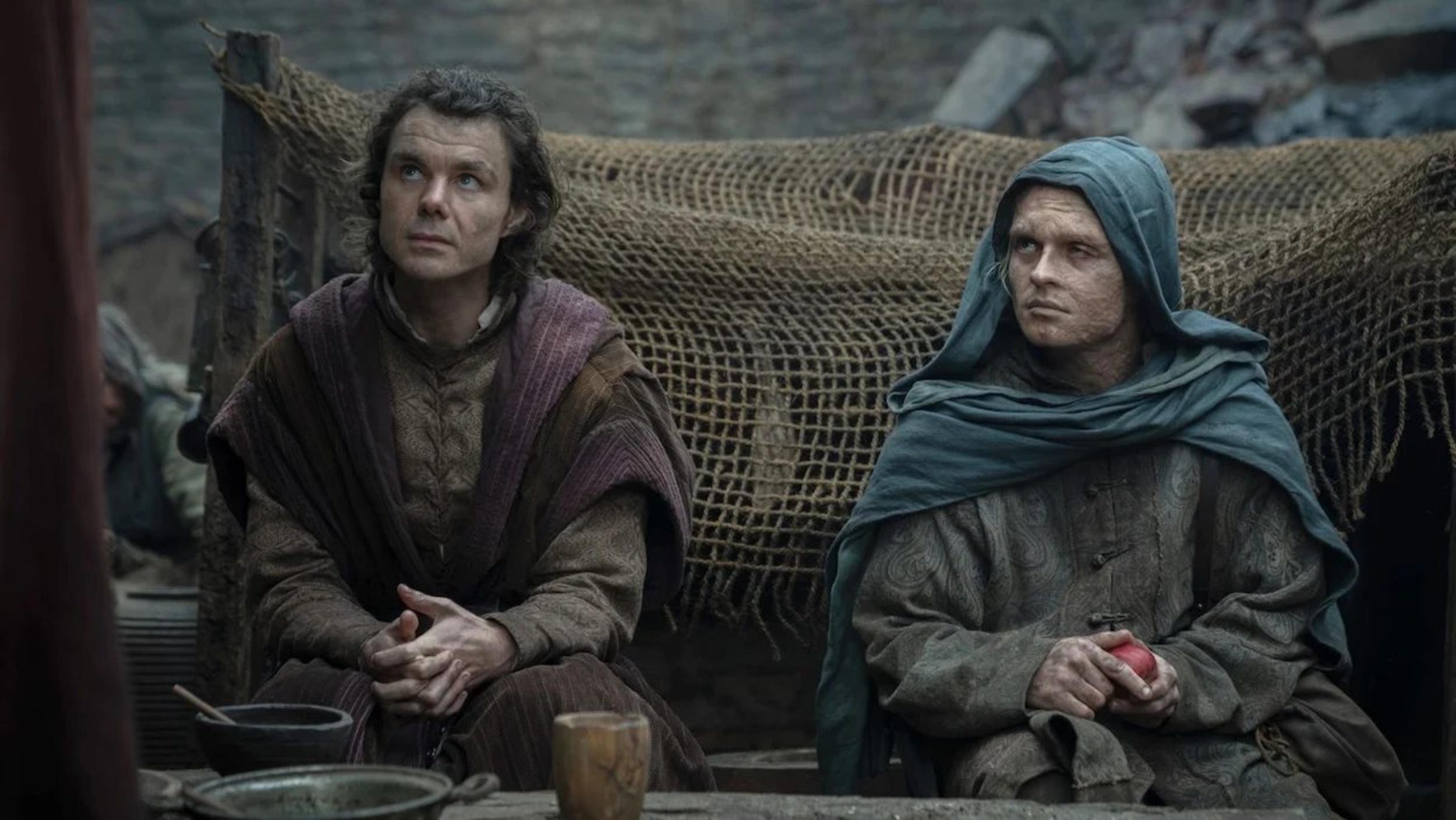 Larys and Aegon in cloaks look up at the same unseen figure on House of the Dragon