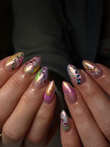 Hands with long painted nails adorned with decorative gems