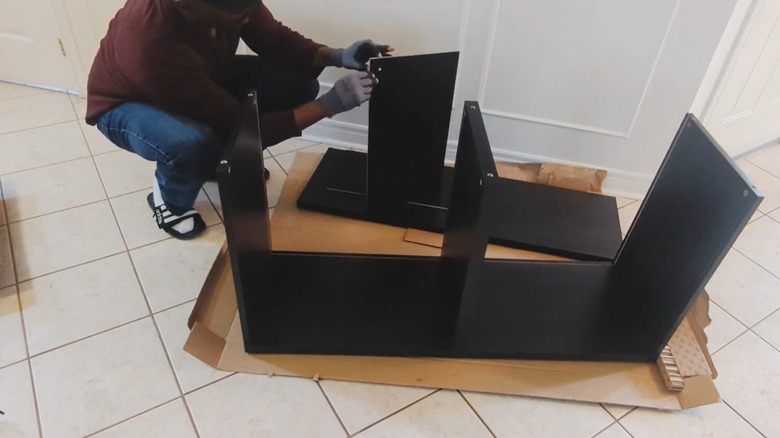 Person assembling an IKEA BESTÅ cabinet