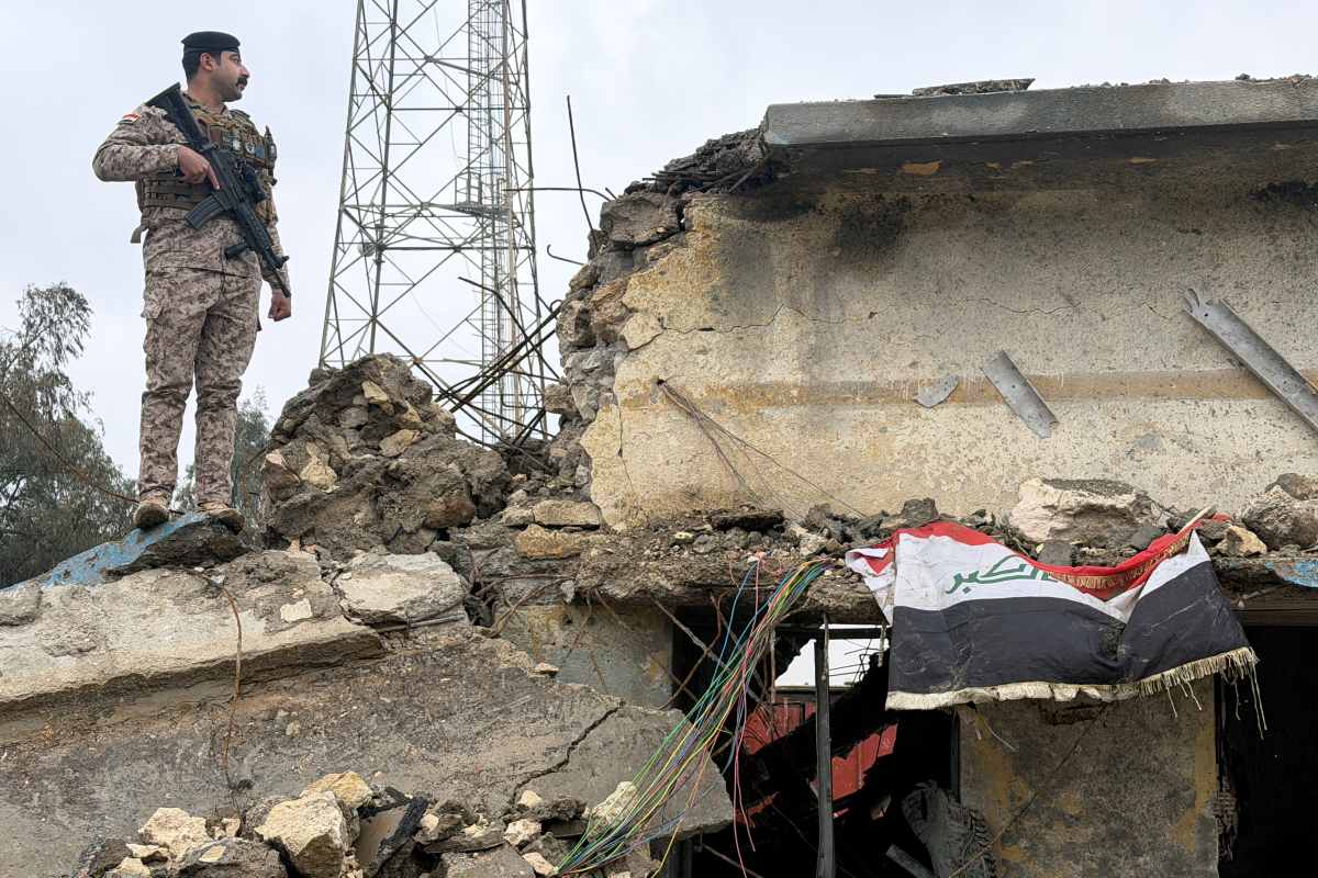 An Iraqi soldier stands guard atop a damaged building at the Iraqi army base in Habbaniyah after it was hit by an airstrike Wednesday, in Anbar province, Iraq, Thursday, March 26, 2026. (AP Photo/Ali Jabar)