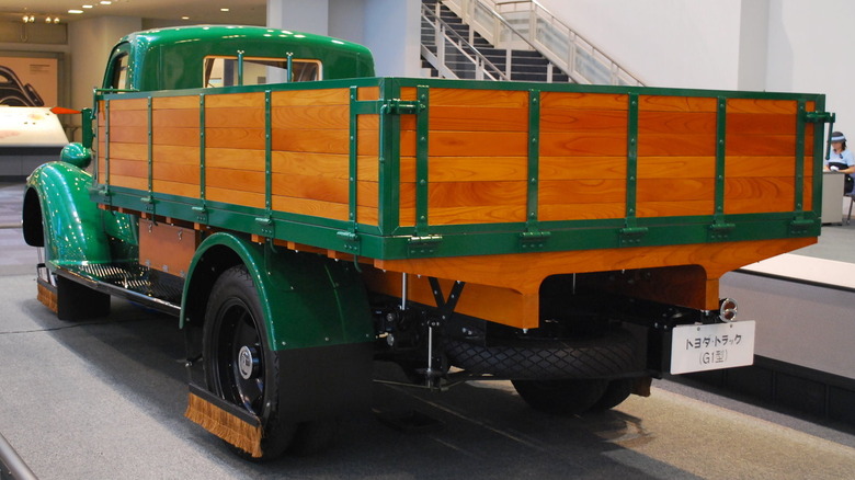 A green Toyoda Model G1 Truck on display with a Japanese sign on its rear end