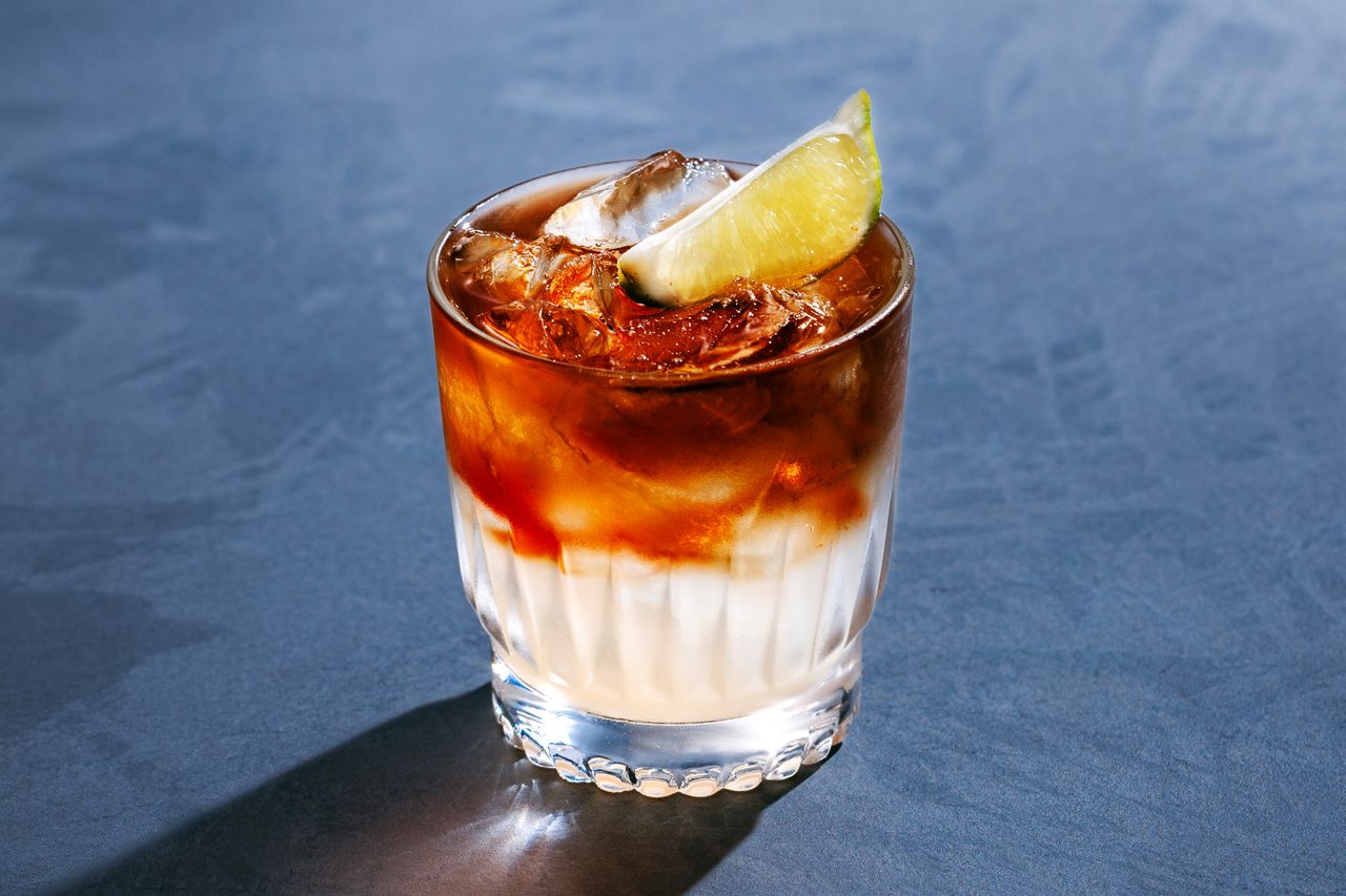 A Corn-n-Oil cocktail on a blue surface.