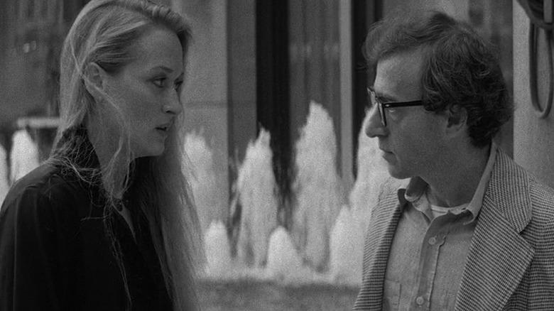 Woody Allen as Isaac Davis and Meryl Streep as Jill Davis in Manhattan, standing and looking at each other in front of a city fountain.